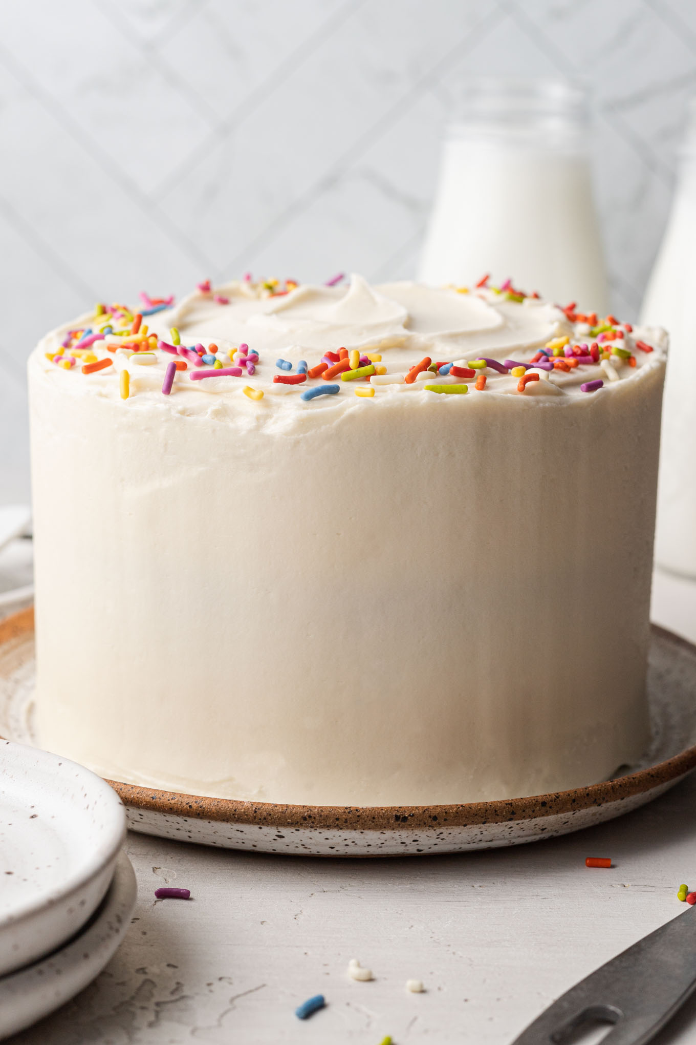 A 6-inch vanilla cake on a speckled white plate. 