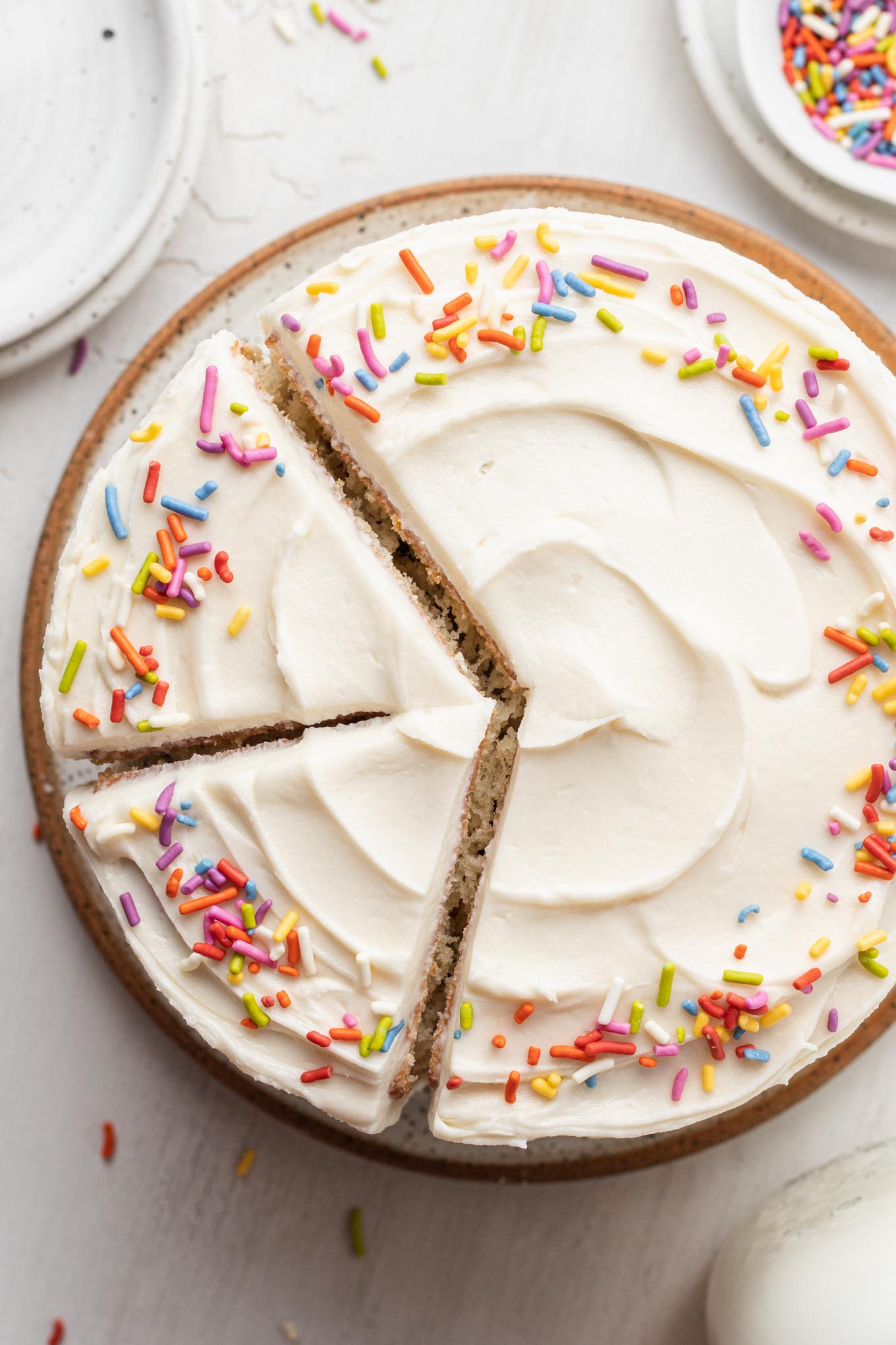 An overhead view of a 6-inch vanilla cake with two slices cut out. 