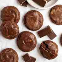 An overhead view of several Andes mint cookies spread out on a piece of parchment paper.