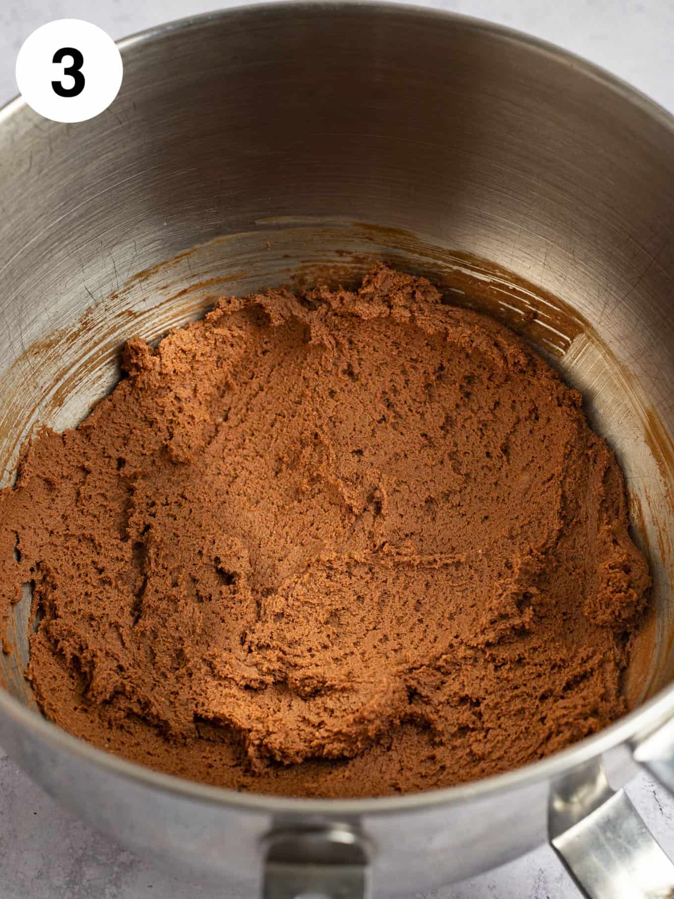 Chocolate cookie dough fully mixed together in the bowl of a stand mixer.