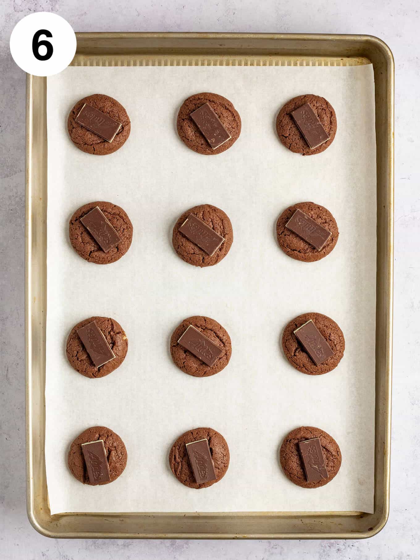 An overhead view of baked chocolate cookies topped with Andes mints.