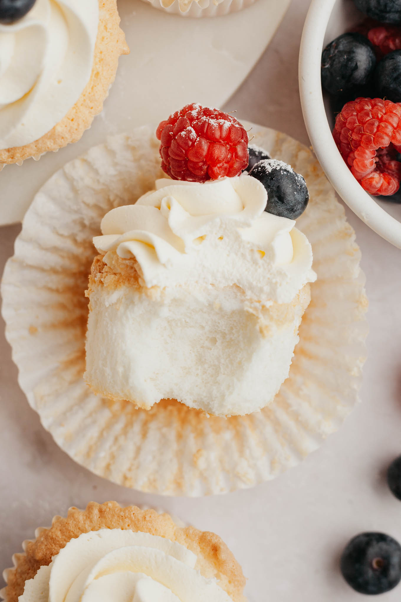 An overhead view of an angel food cupcake with a bite missing, turned on its side. 