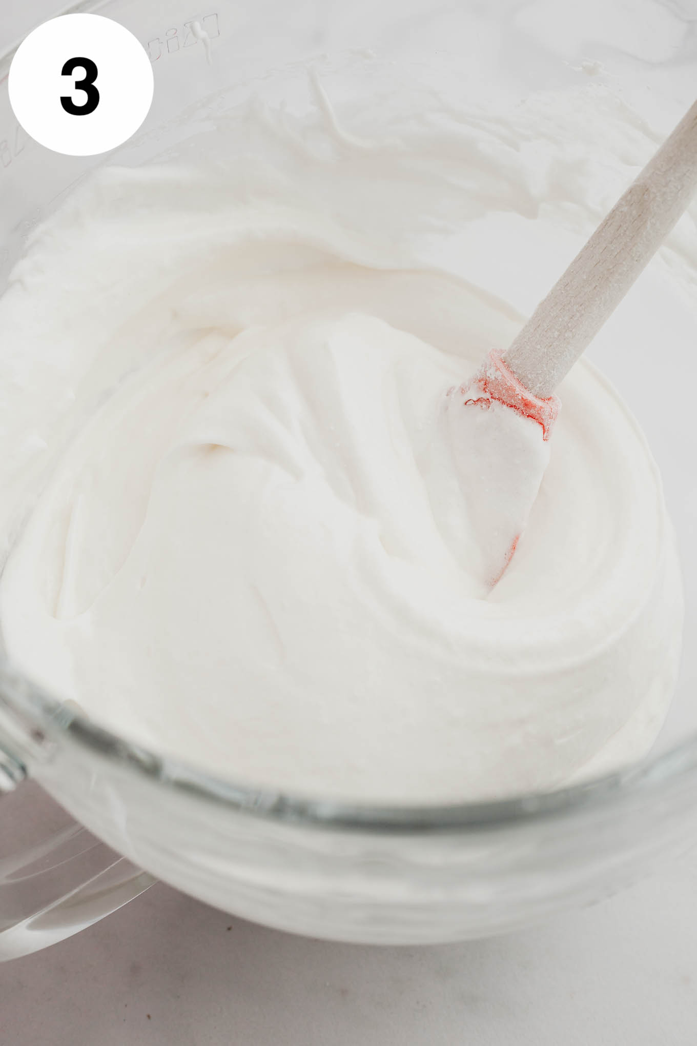 Angel food cupcake batter in a glass mixing bowl. 