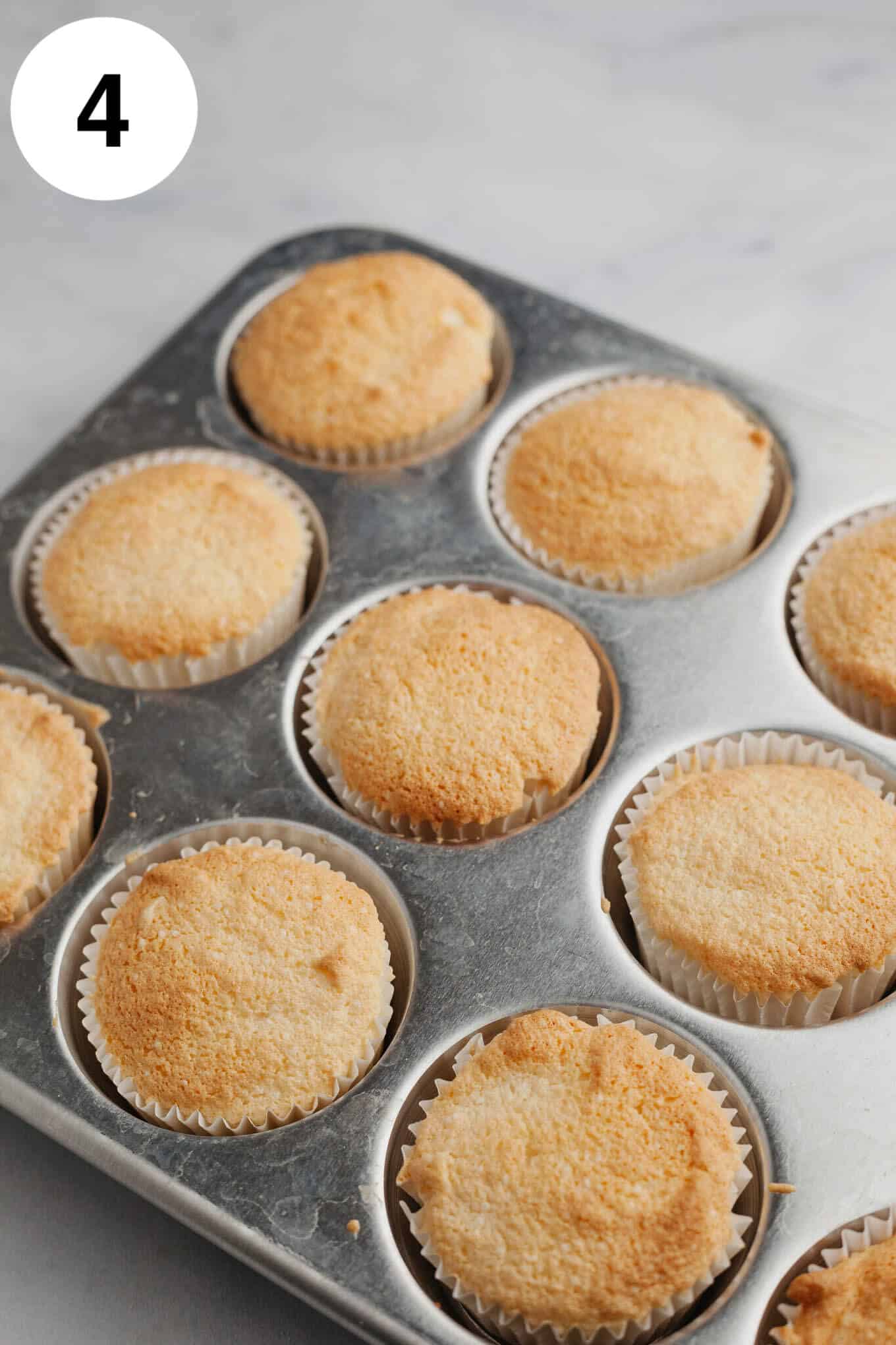 Unfrosted angel food cupcakes in a cupcake pan. 