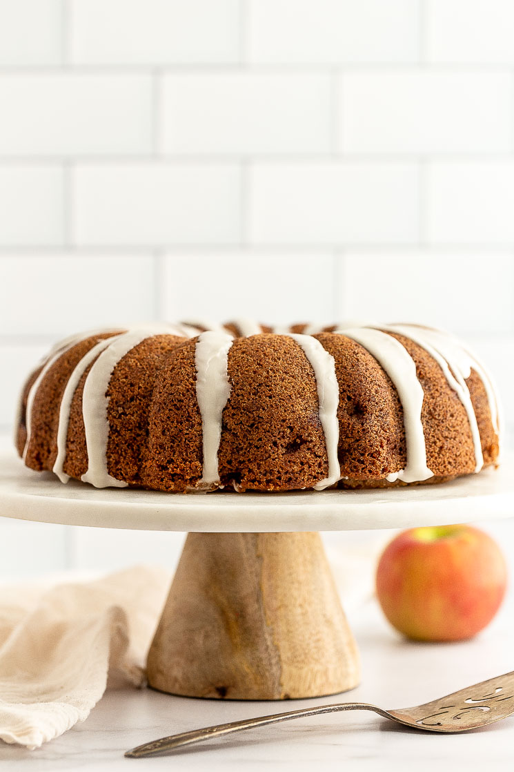 An apple cake sitting on top of a marble cake stand.