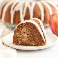 A slice of apple cake on a white plate.