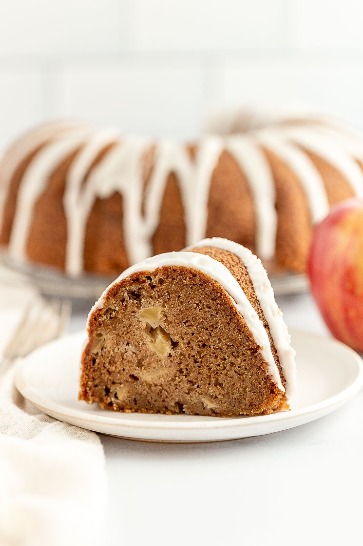 A slice of apple cake on a white plate.