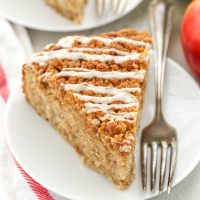 A slice of apple coffee cake sitting on a white plate.