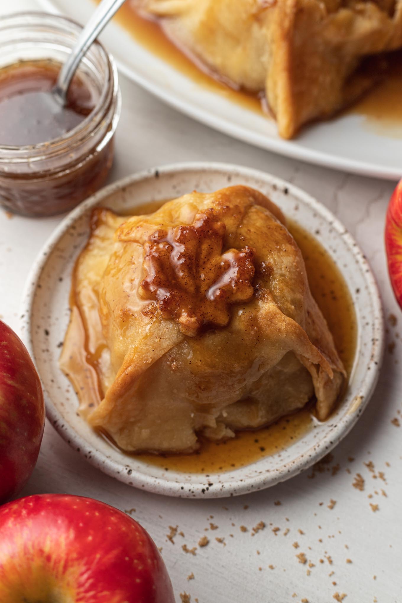 An apple dumpling with sauce on a dessert plate. 