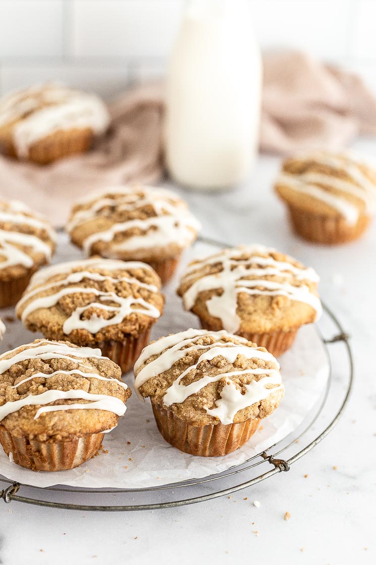 Glazed apple muffins on top of a round wire rack. 