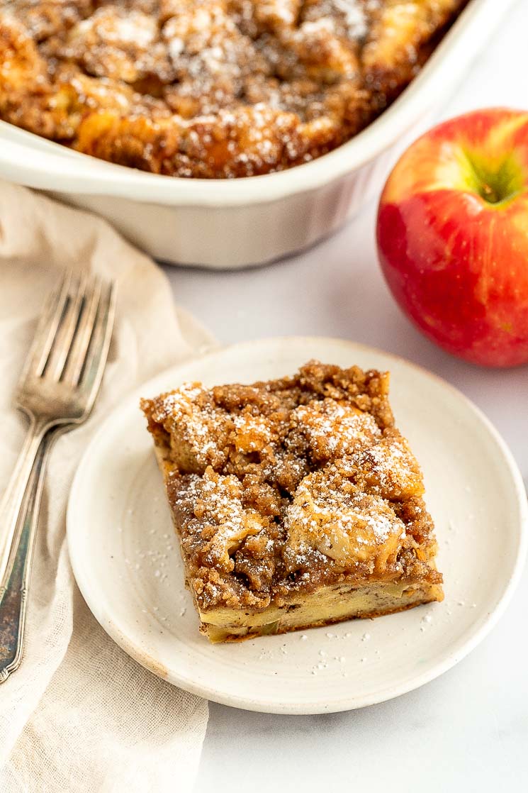 A slice of apple streusel french toast casserole on a white plate.