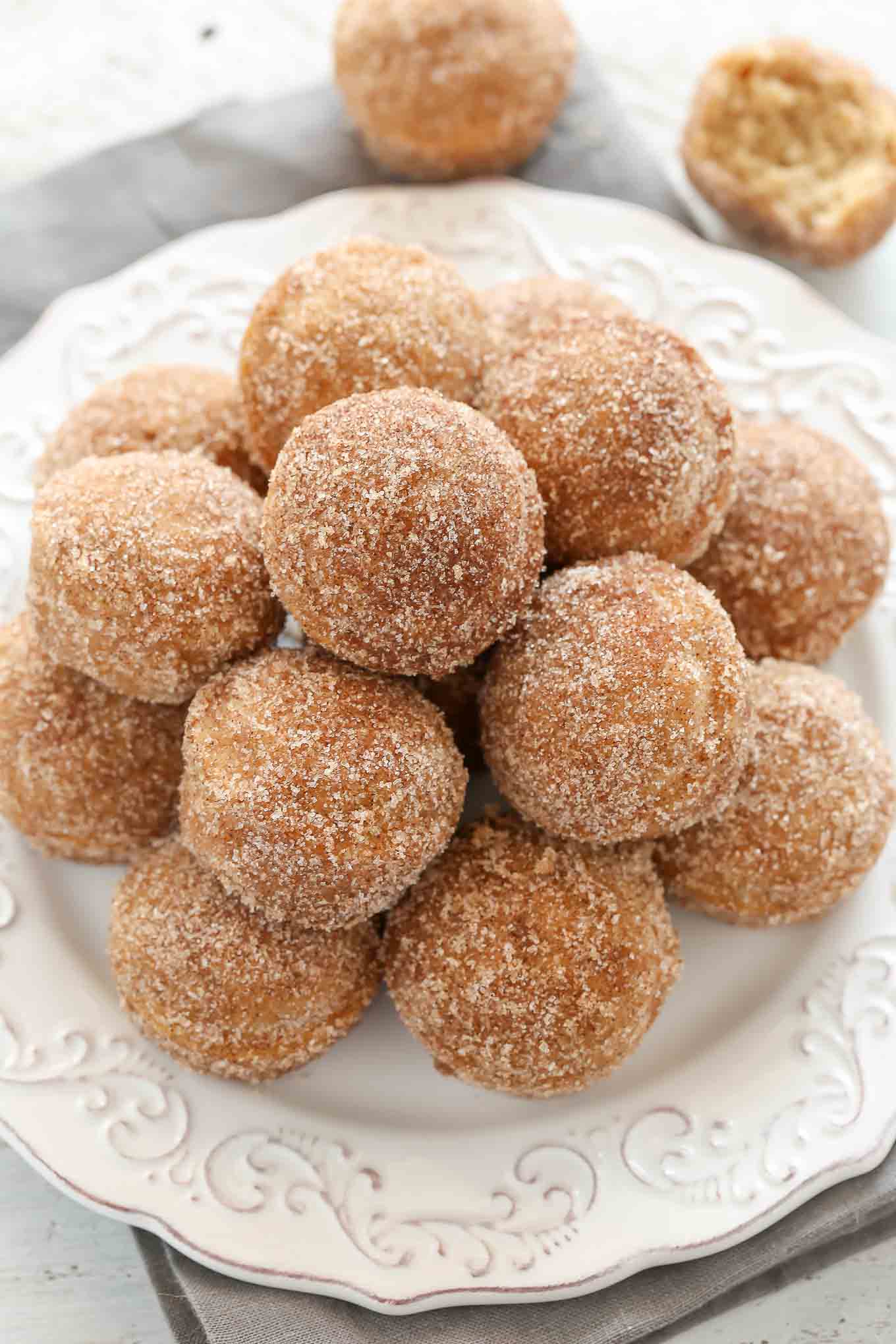 Overhead view of a white plate piled high with apple cinnamon donut holes. 