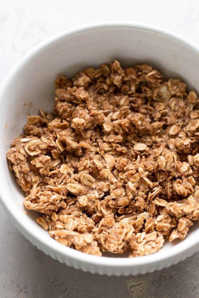 A white bowl full of oatmeal crisp mixture.