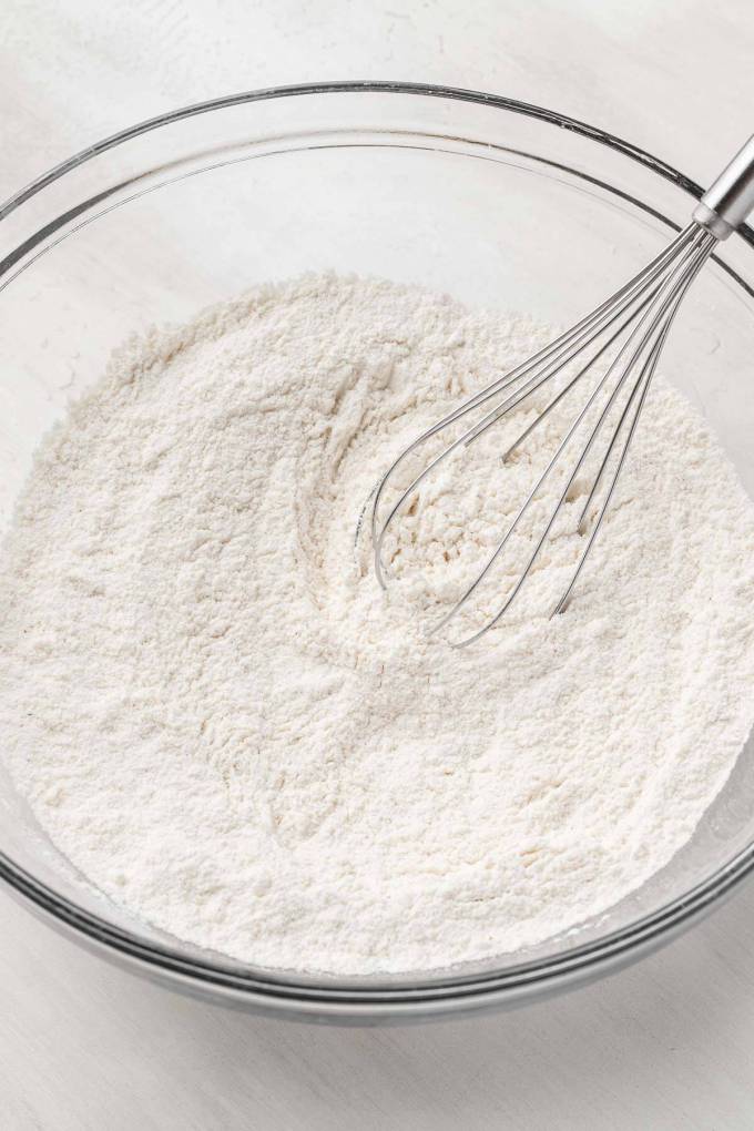 An overhead view of the dry ingredients for donuts in a mixing bowl.