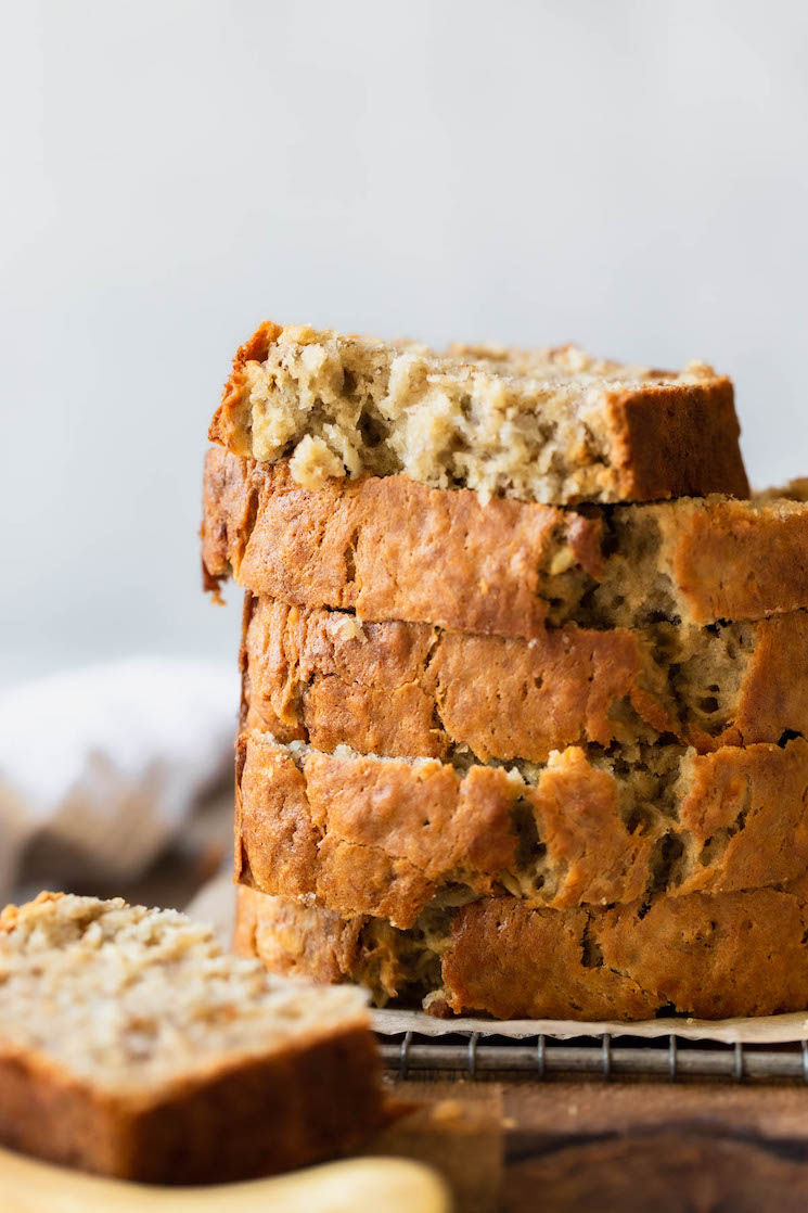 A stack of banana bread slices on top of an antique cooling rack.