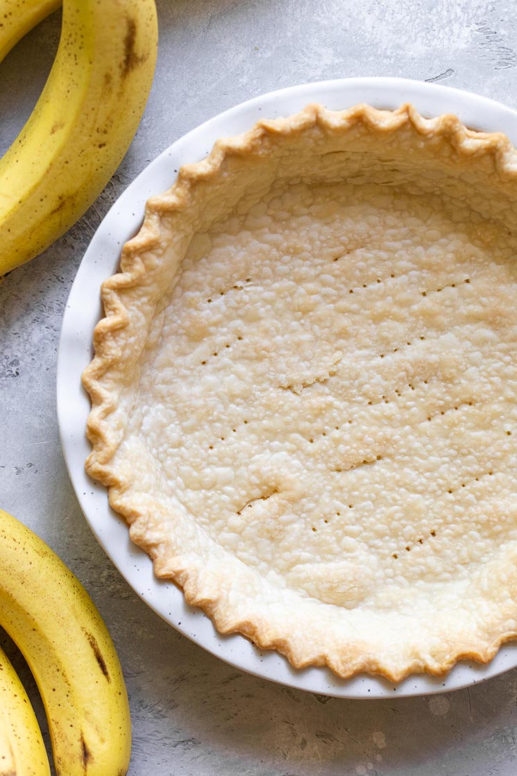 A baked pie crust in a speckled pie plate ready to put the pie filling and whipped cream into.