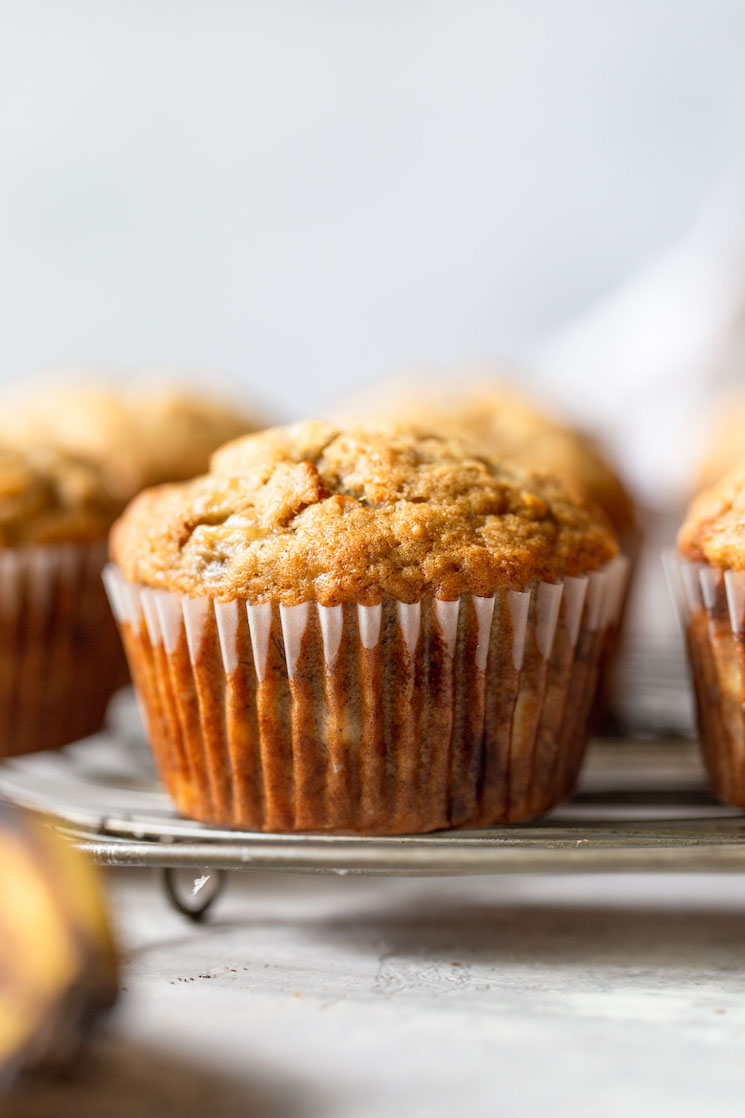 A batch of banana muffins on a round cooling rack.