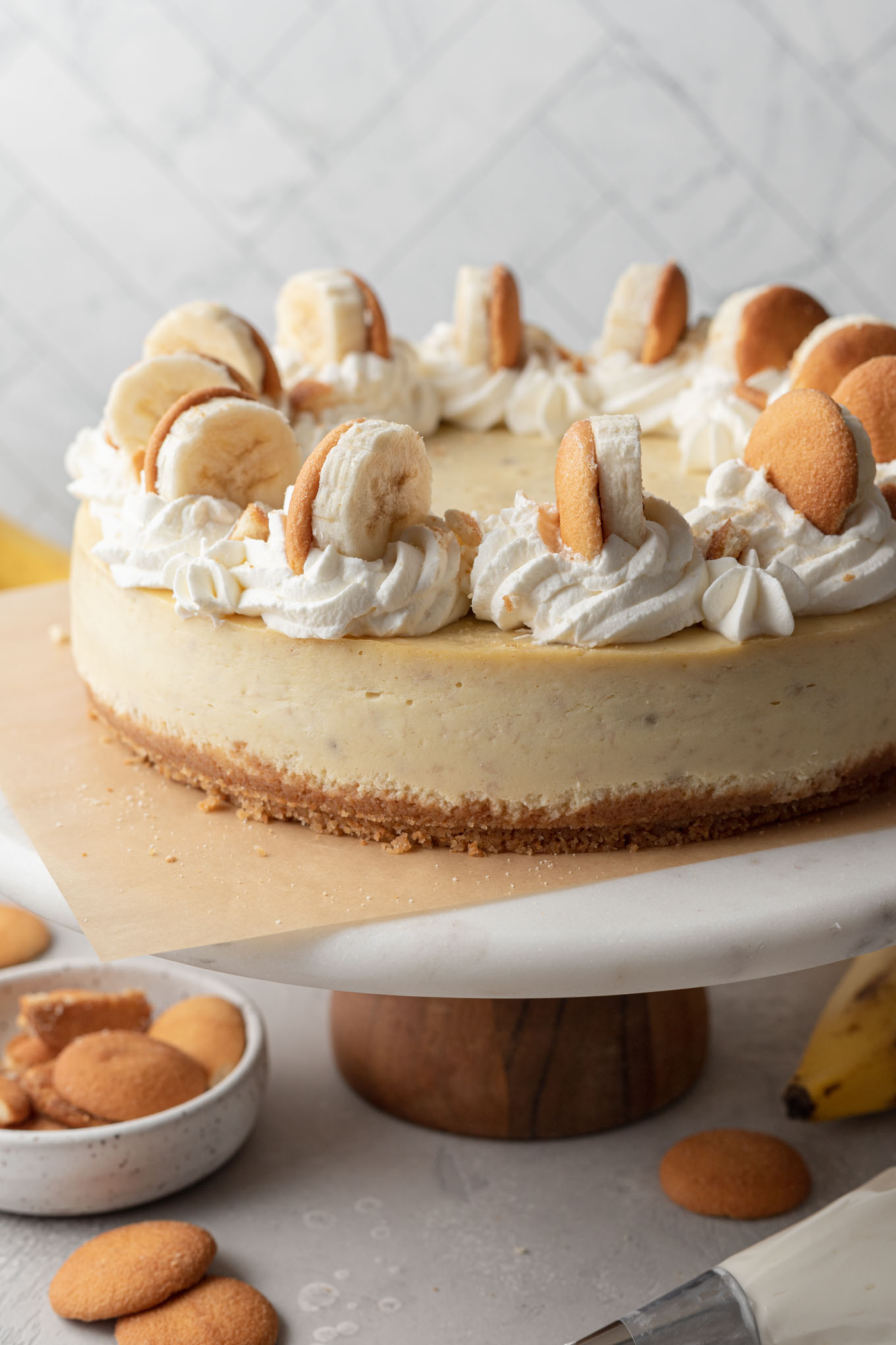 A banana pudding cheesecake on a cake stand. 