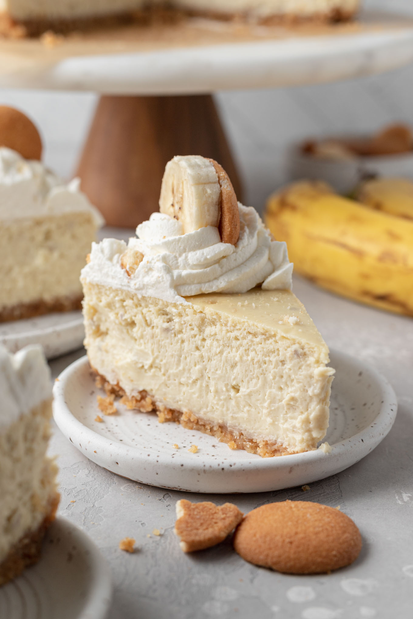 A slice of banana pudding cheesecake on a white plate. 