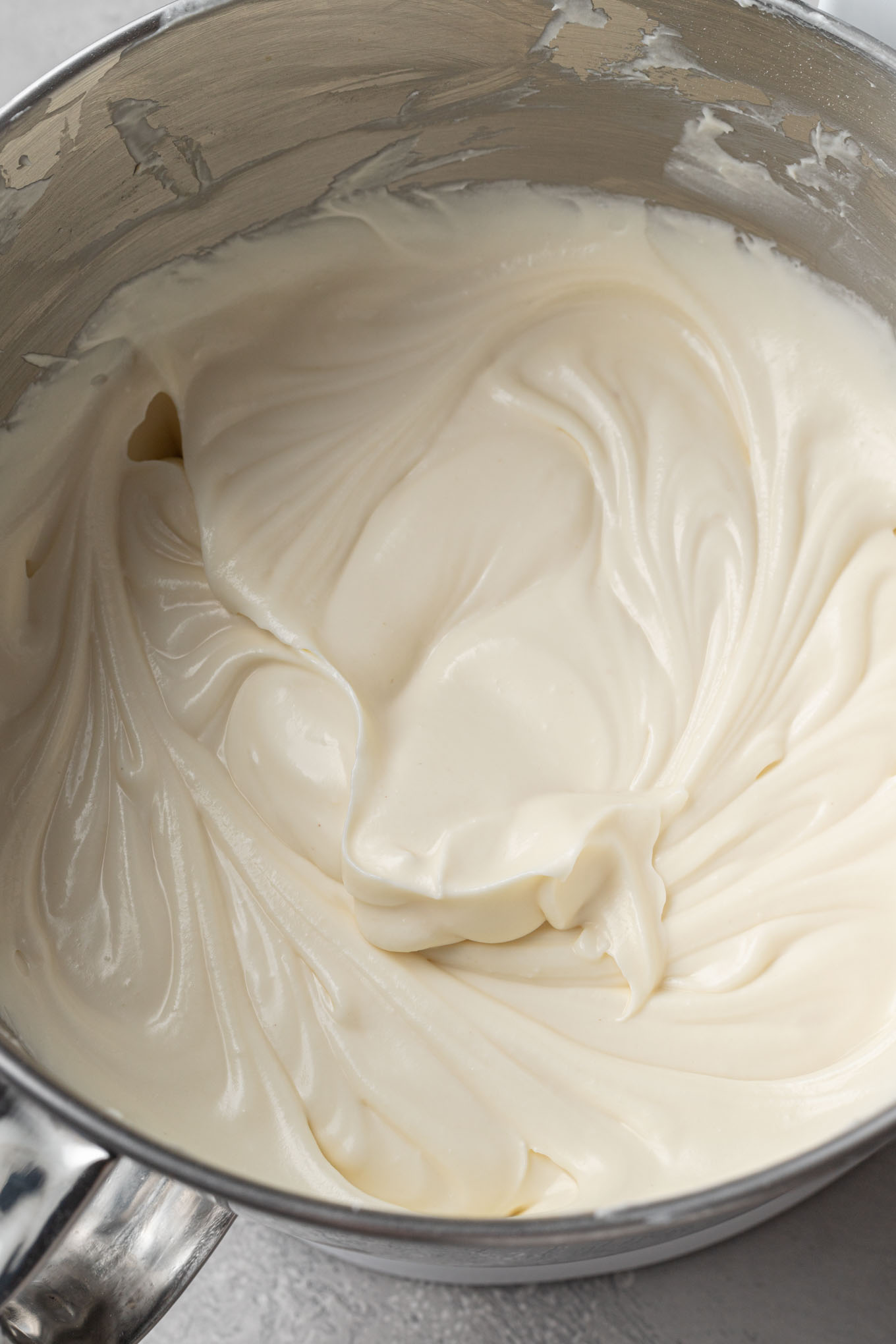 An overhead view of cheesecake filling in a mixing bowl.