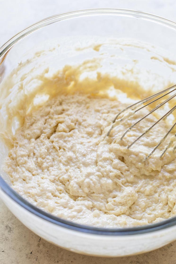 All of the ingredients mixed together in a glass bowl with a metal whisk. 