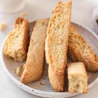 A few slices of biscotti on a white speckled plate.