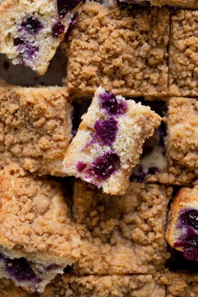 An overhead view of a sliced blueberry coffee cake. Some slices have been turned on their side. 