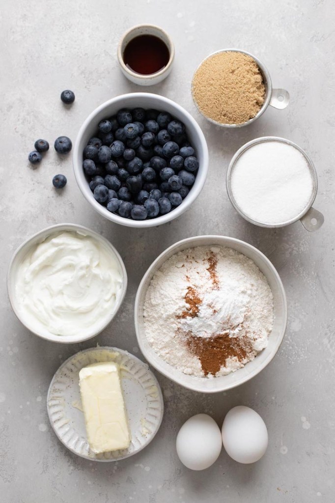 An overhead view of the ingredients needed to make a blueberry sour cream coffee cake. 