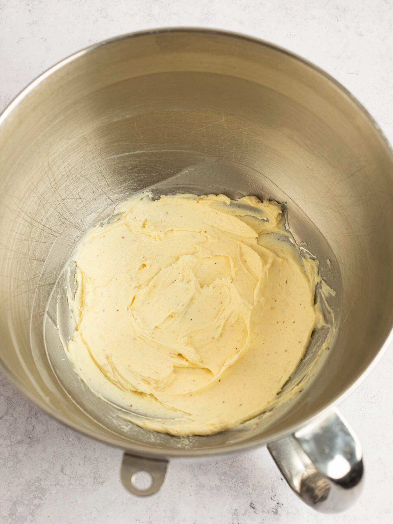 Regular butter and browned butter mixed together in the bowl of a stand mixer.