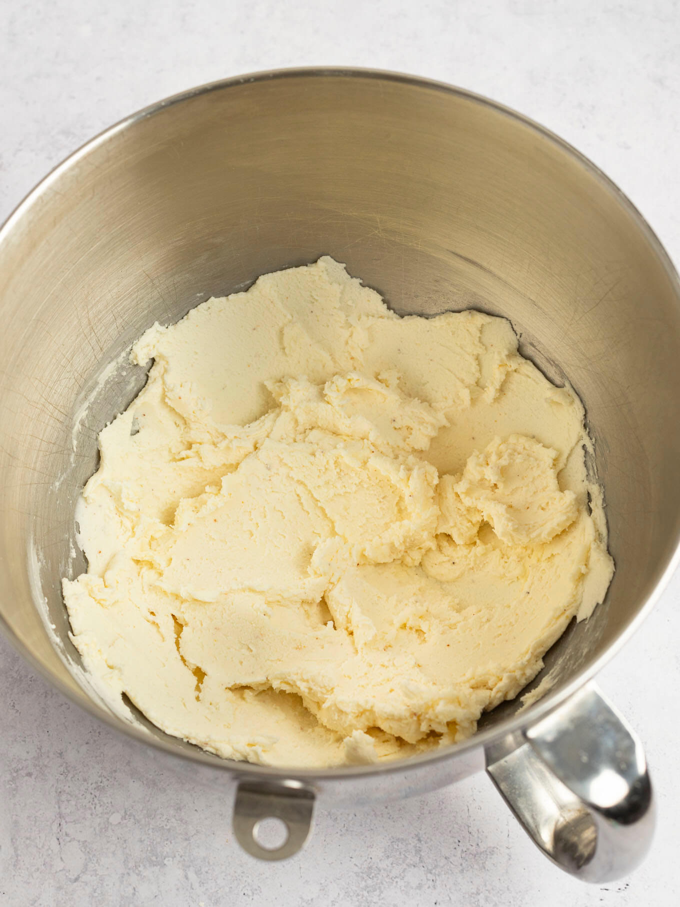 Butter and powdered sugar mixed together in the bowl of a stand mixer.