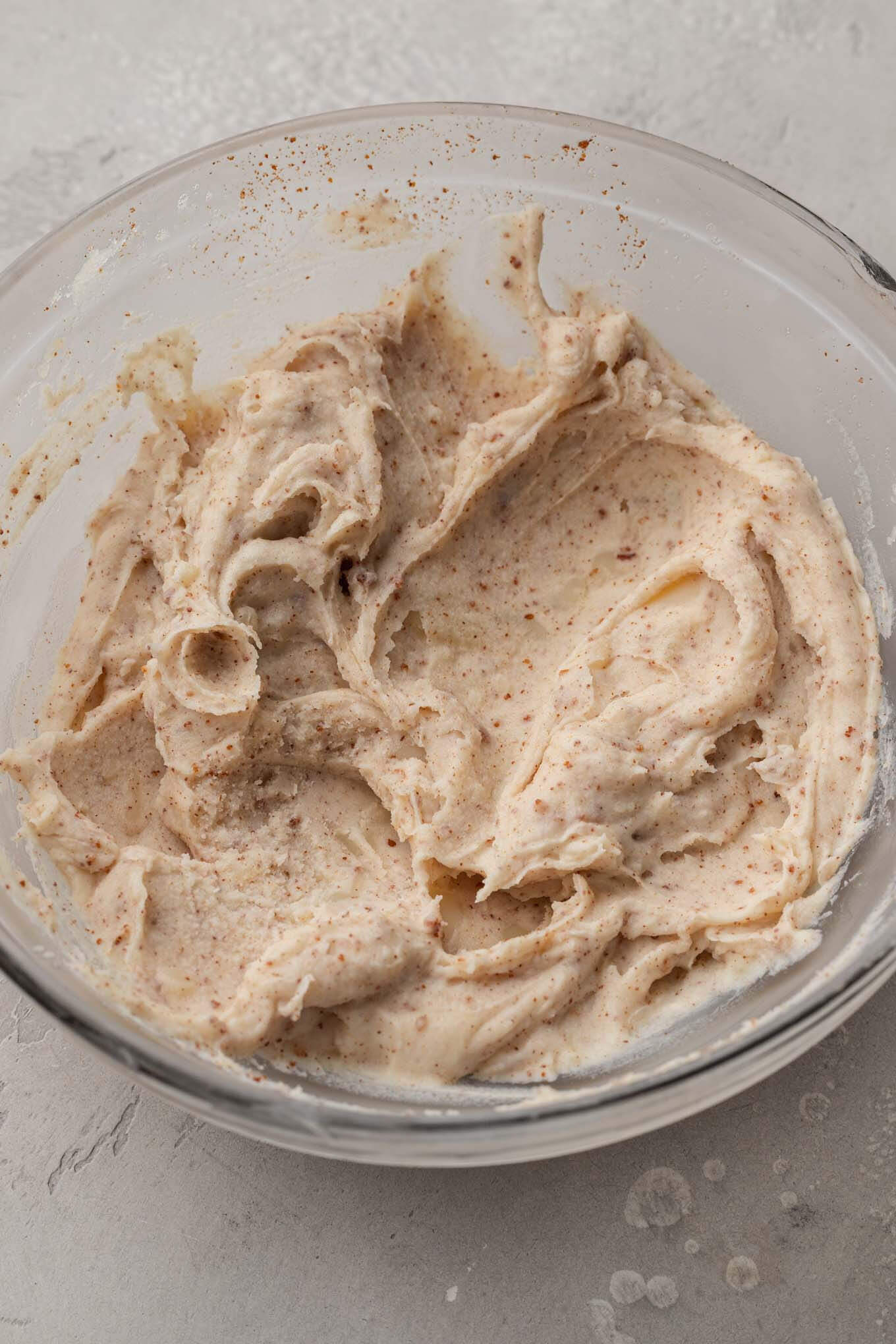 An overhead view of solidified browned butter in a glass mixing bowl. 