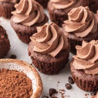 Several brownie bites topped with chocolate whipped cream.