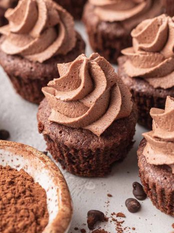 Several brownie bites topped with chocolate whipped cream.