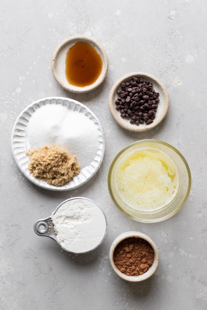 Overhead view of the ingredients needed to make a brownie in a mug. The ingredients are in individual dishes. 