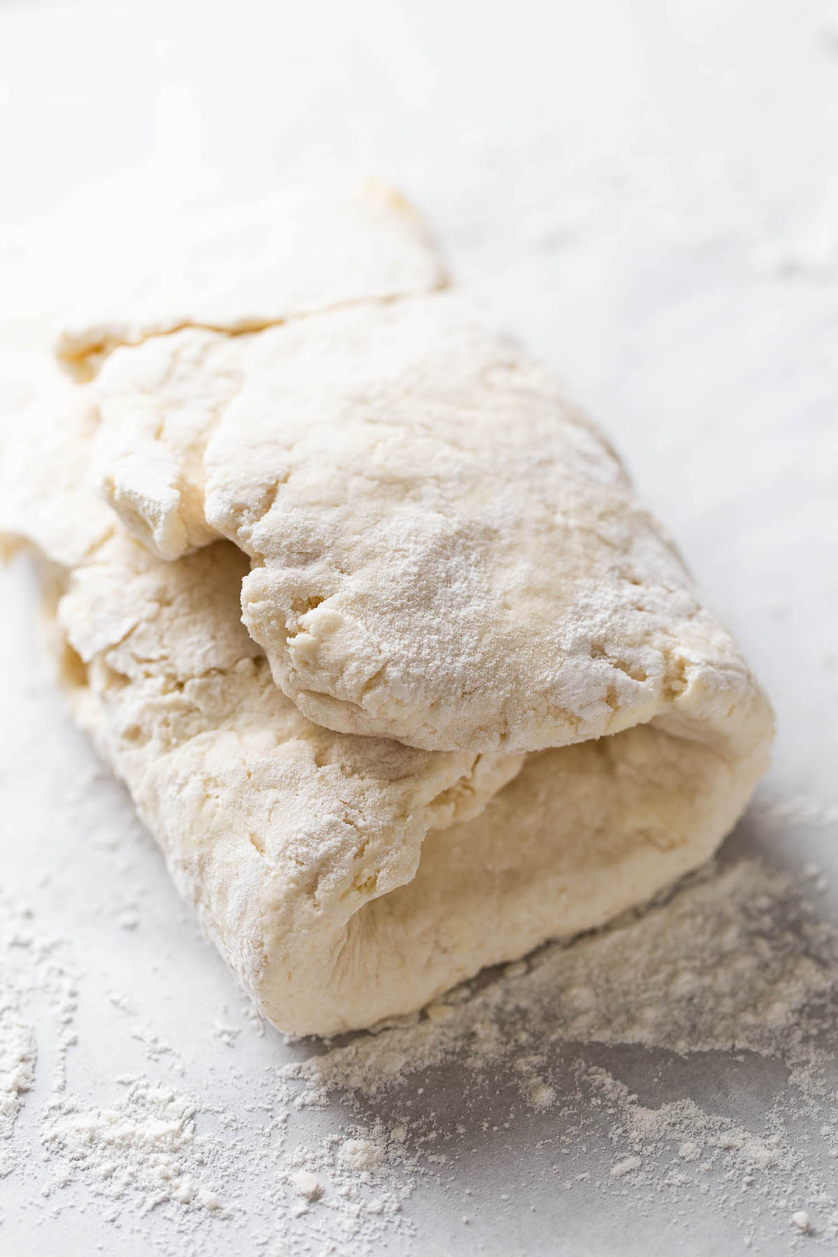 Raw biscuit dough that's been folded into thirds.