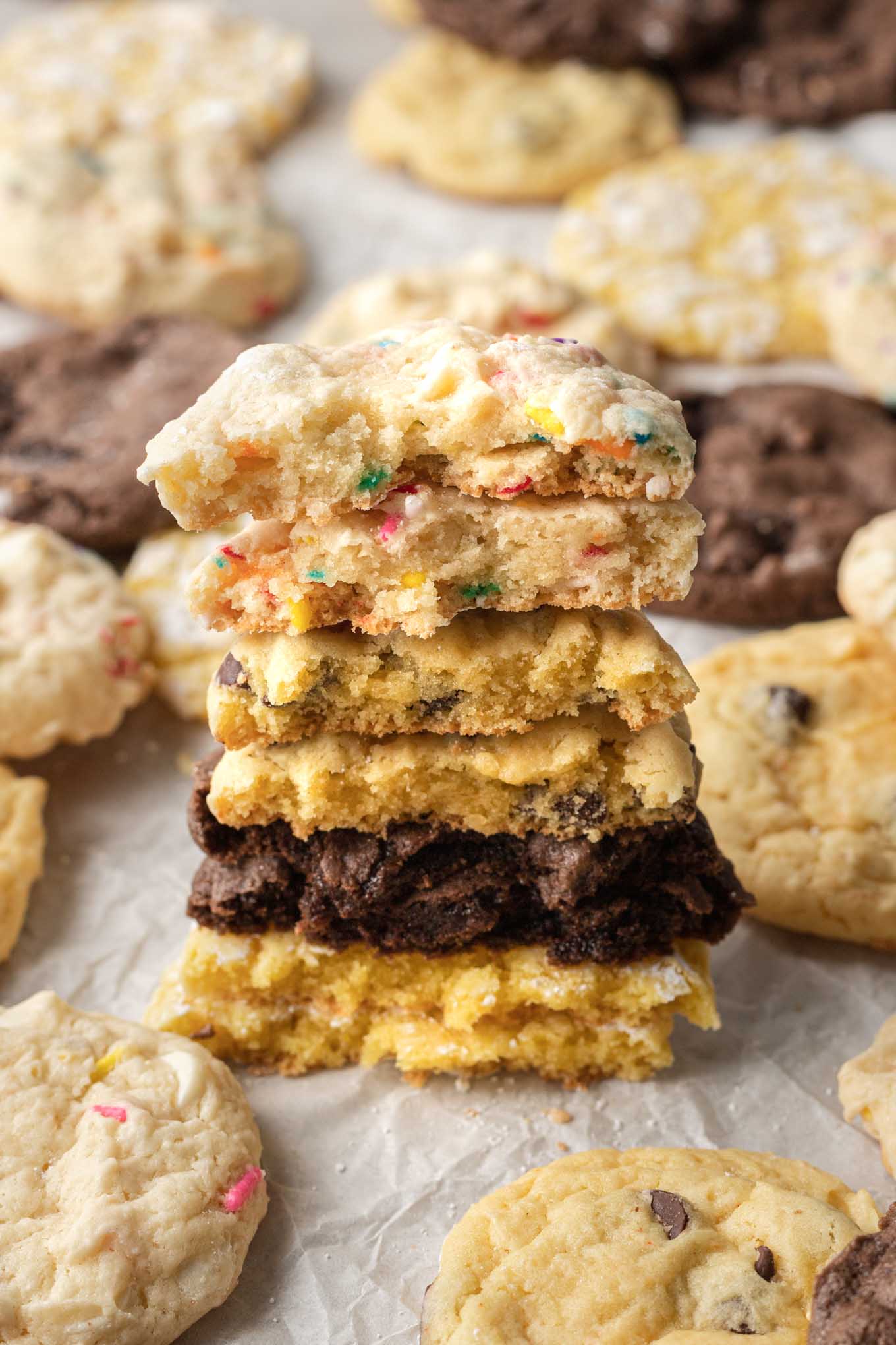 A stack of halved cake batter cookies, surrounded by additional cookies. 