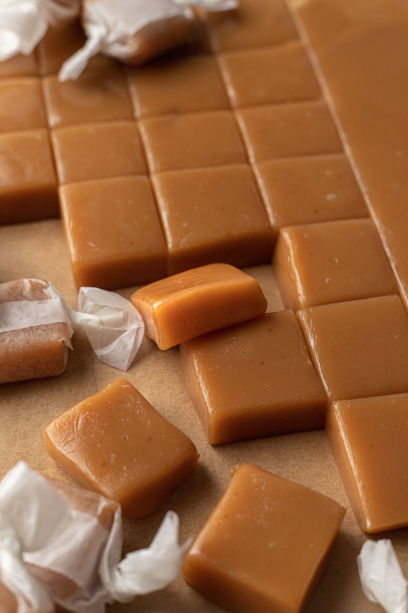 Homemade caramel candies sliced on a piece of parchment paper.