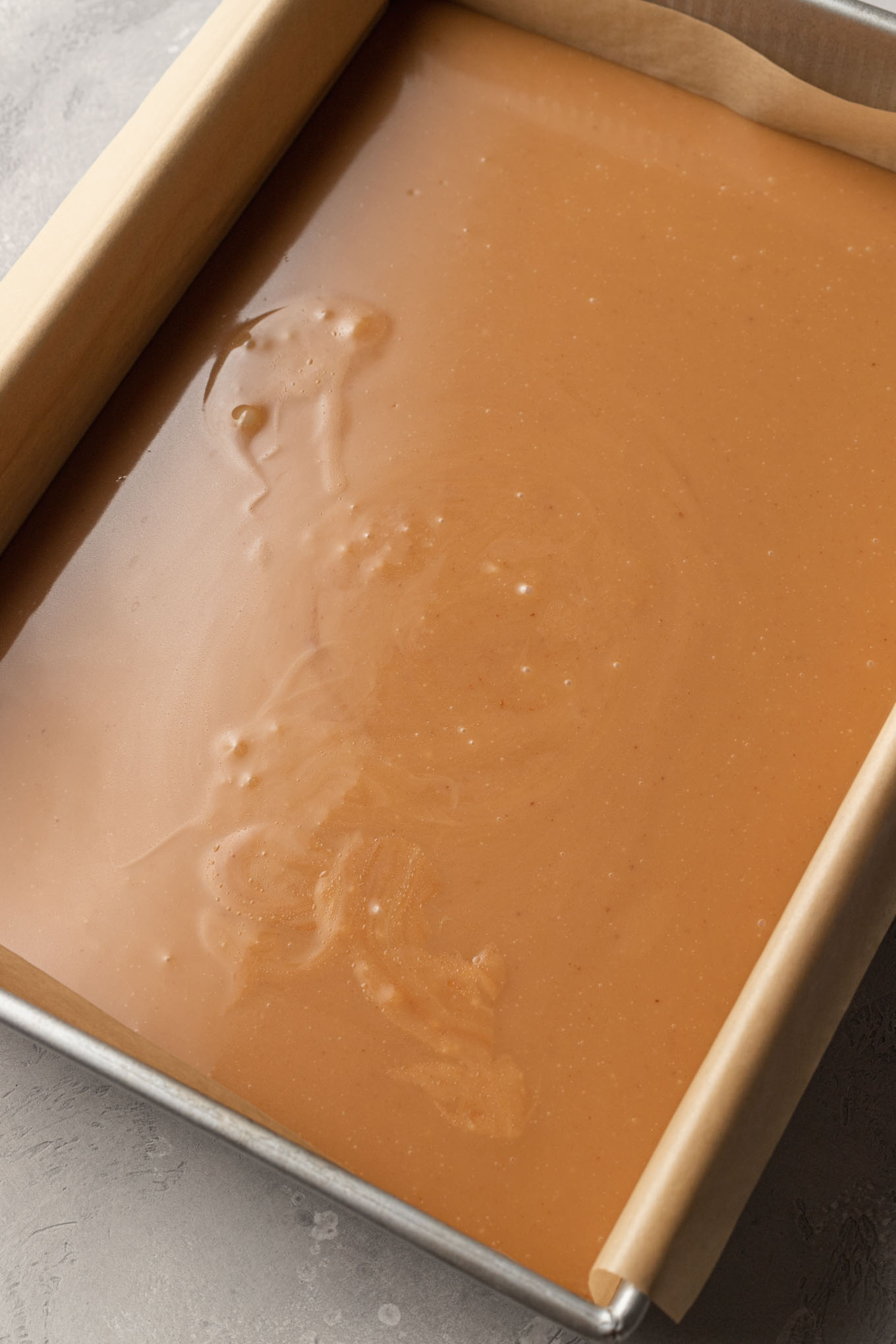 Warm caramel mixture cooling in a baking dish. 