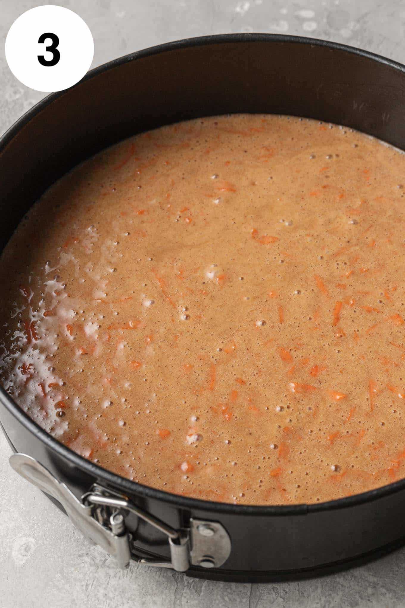 An overhead view of carrot cake batter in a springform pan. 