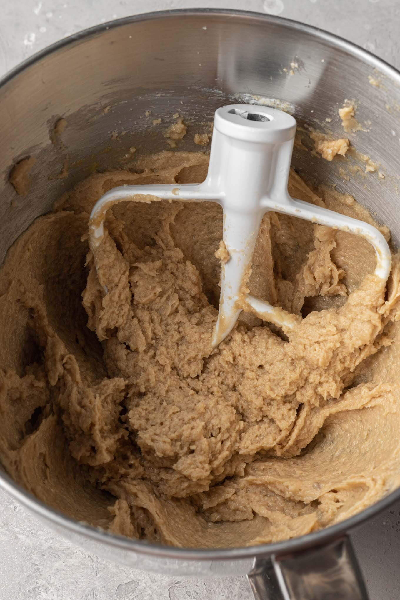 Creamed butter and sugar in a metal mixing bowl, with a paddle attachment.