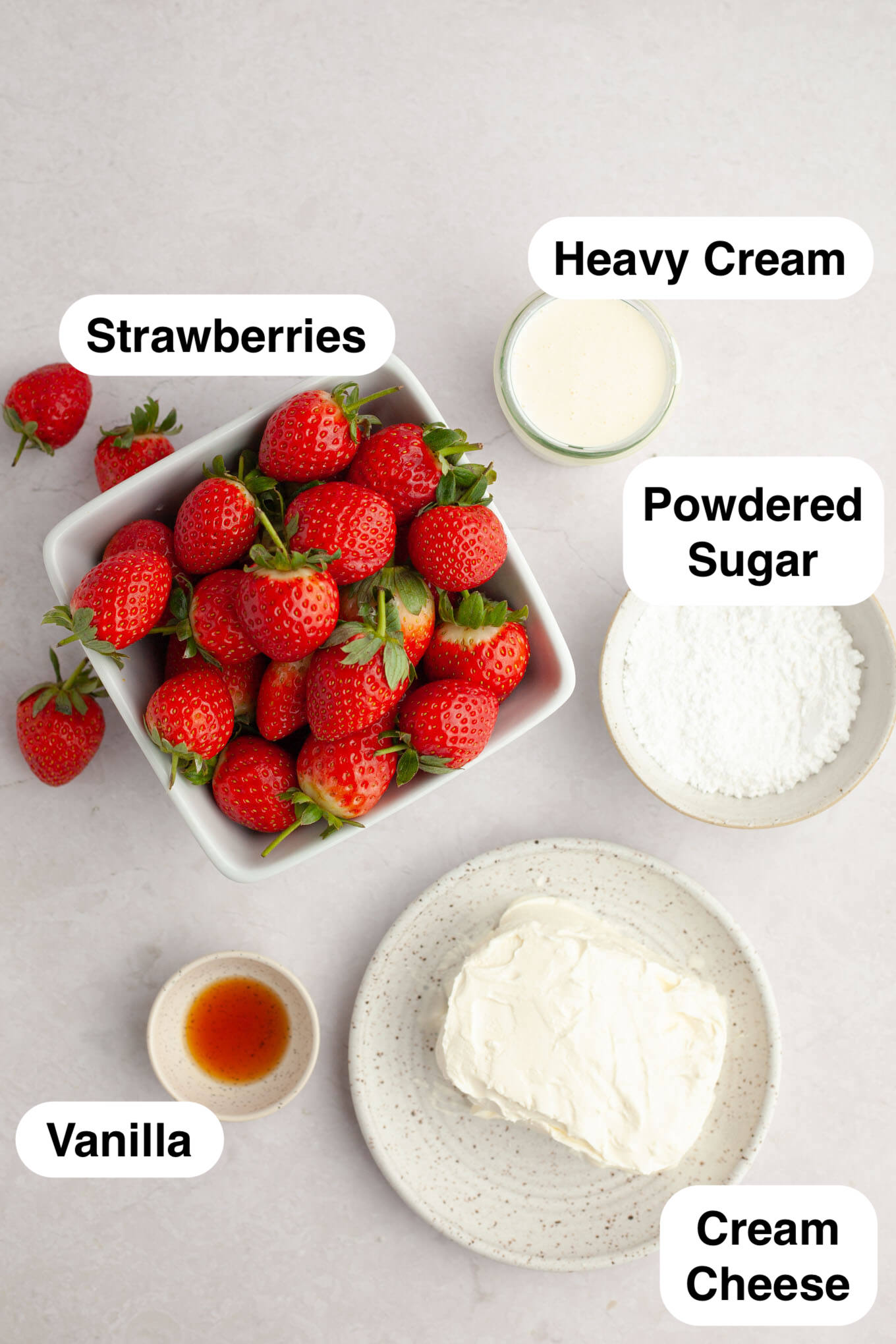 An overhead view of the ingredients needed to make strawberries filled with cheesecake. 