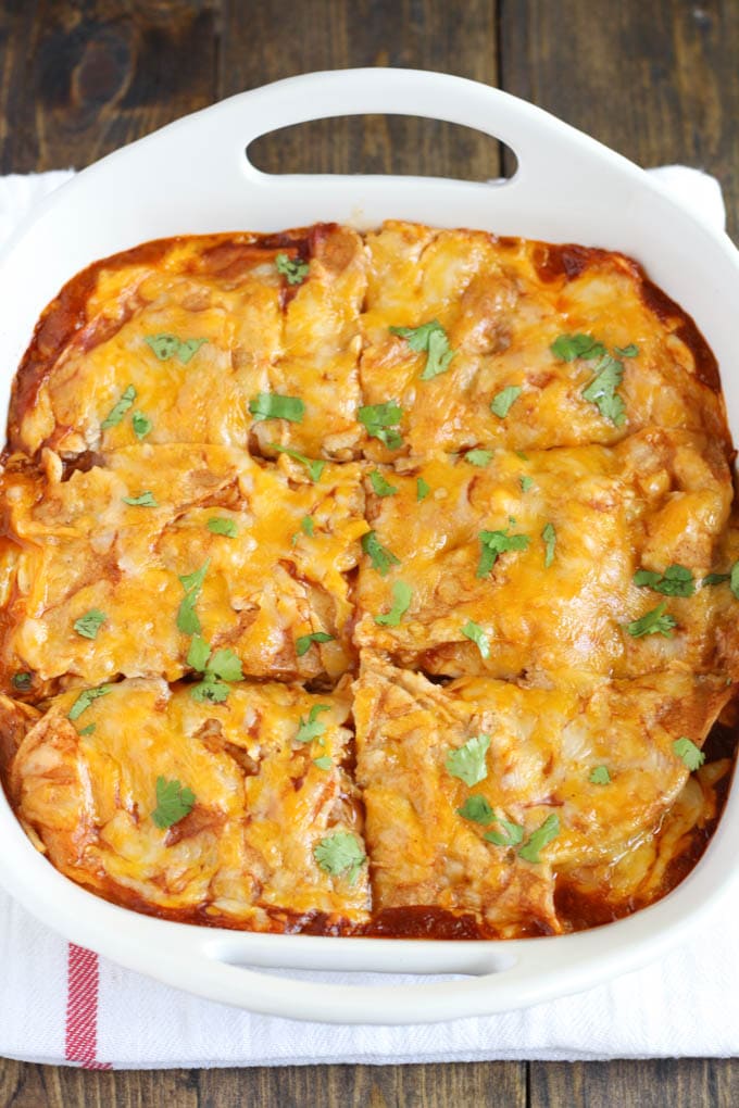 Overhead view of chicken enchilada casserole in a white baking dish. 