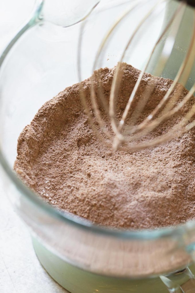 The dry ingredients for chocolate cake mixed together in a clear mixing bowl.