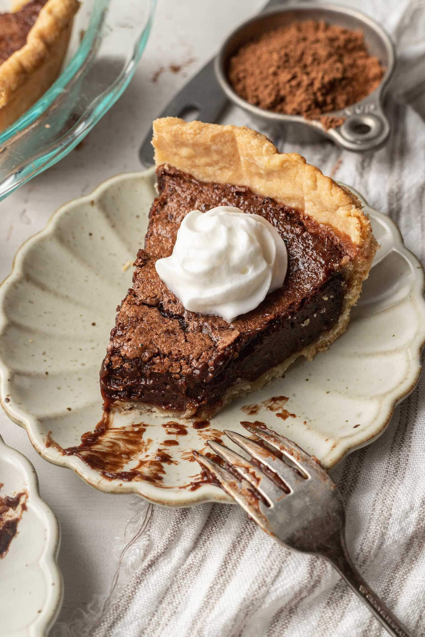 A slice of chocolate pie with a bite missing. A fork rests on the plate. 