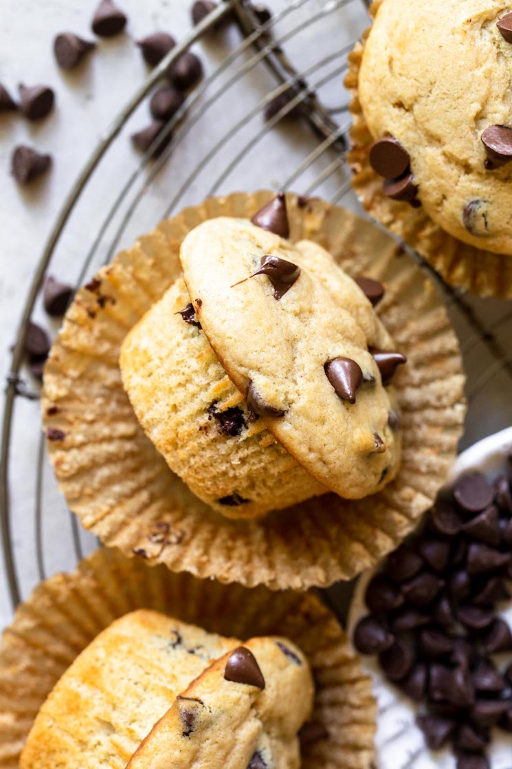 A muffin taken out of the liner and laying on its side on top of an antique round cooling rack.