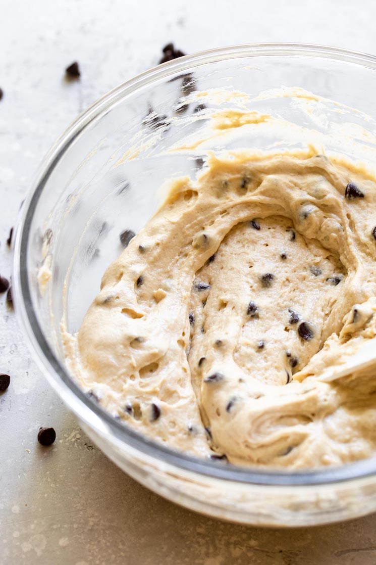 A glass bowl holding muffin batter that has been mixed up.