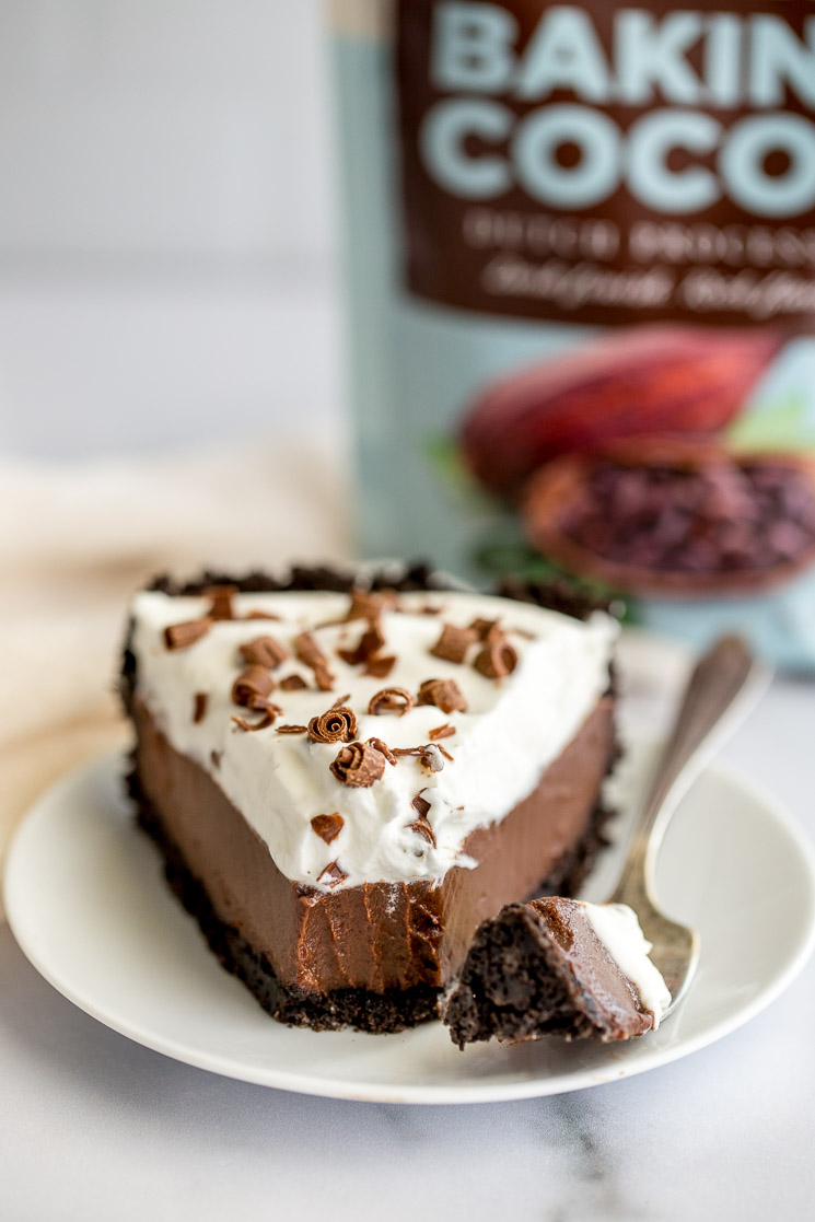 A slice of chocolate cream pie sitting on a white plate.