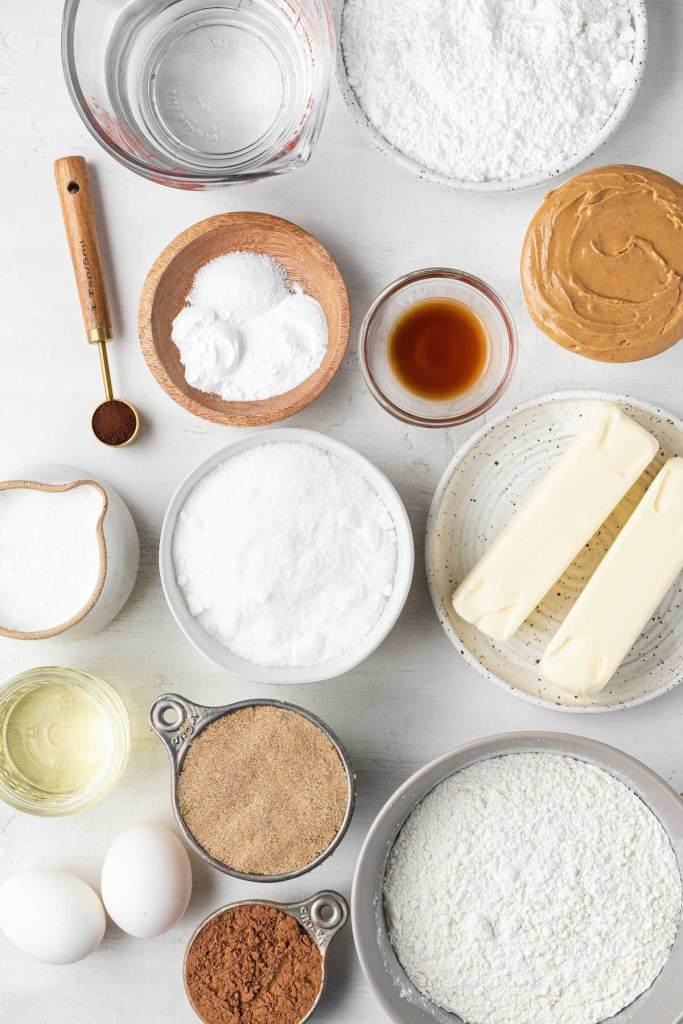 An overhead view of the ingredients needed to make a chocolate cake with peanut butter frosting. 