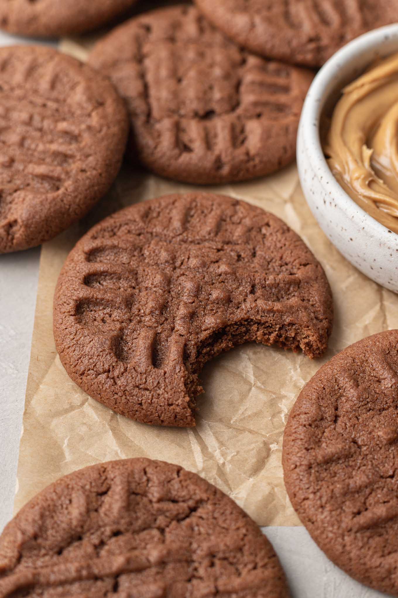 A close-up view of a chocolate peanut butter cookie with a bite missing. 