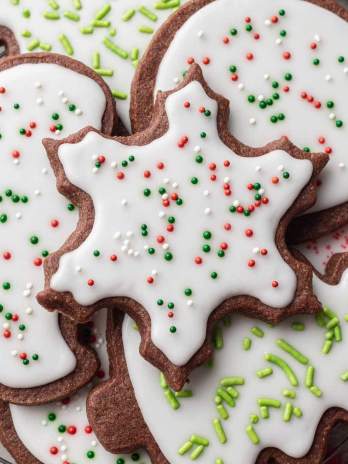 Several iced chocolate sugar cookies on a wire cooling rack.